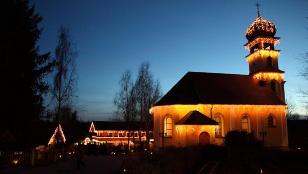 Die beleuchtete Kirche des Bayern-Park im Dunkeln
