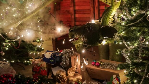 Ein Animatronic-Drache mit weihnachtlicher Dekoration in der Themenfahrt "Drachen Magic" im Magic Park Verden